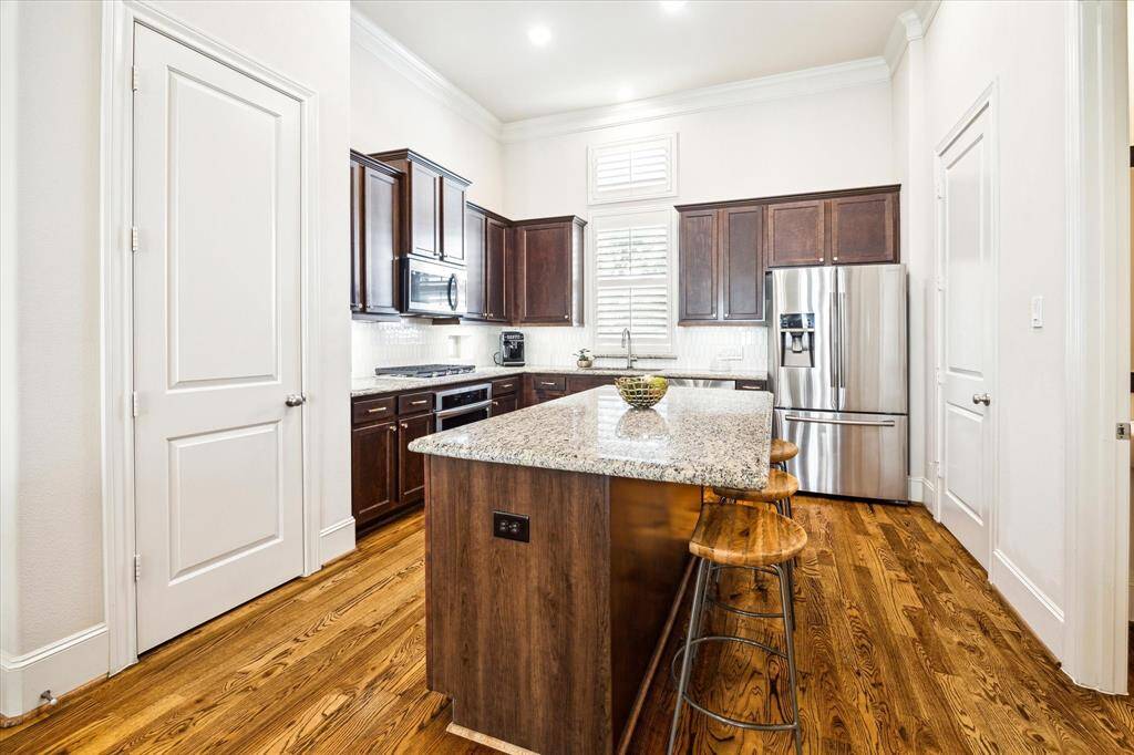 Great functional kitchen with island, pantry, stainless steel appliances, and an adjacent powder bath and laundry room