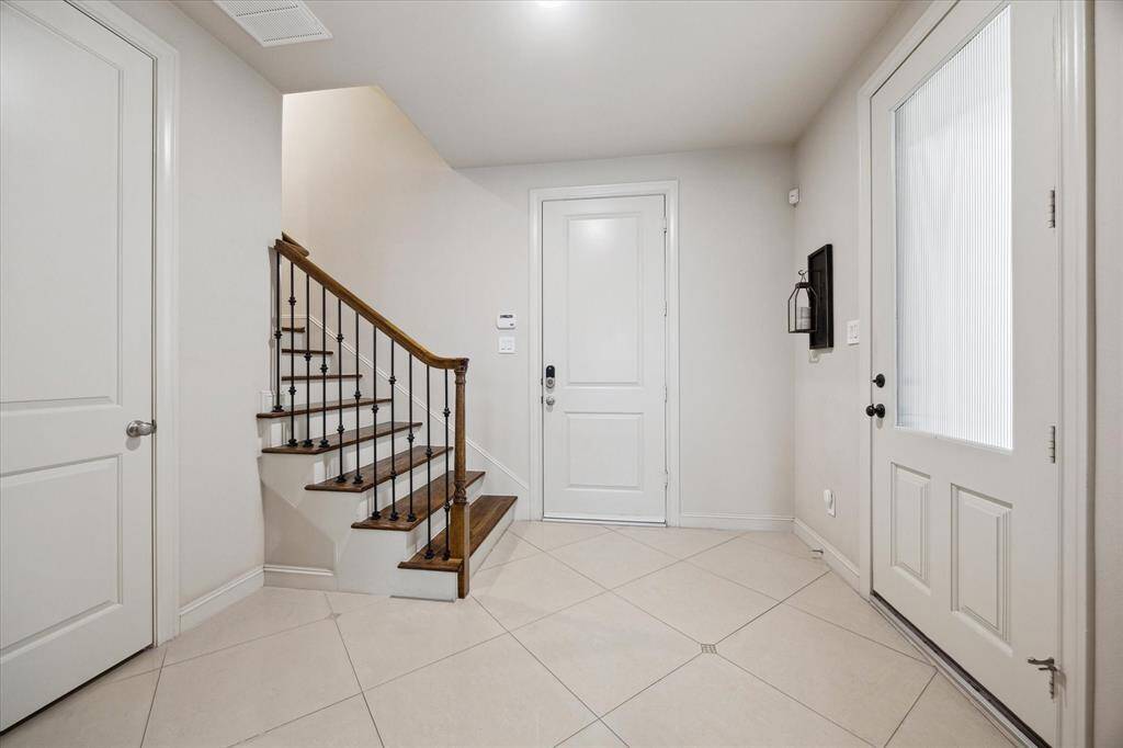 First floor entrance with doors to the garage, coat closet, and first floor bedroom or office