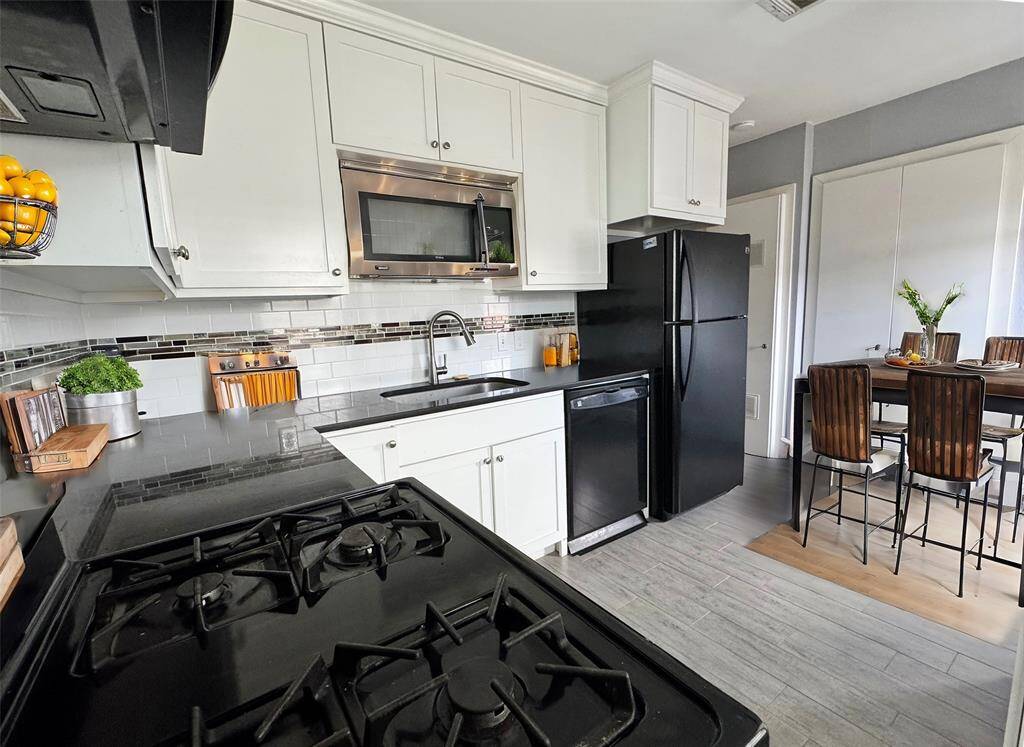 Kitchen features plenty of space for a breakfast table. Fully equipped. Access to back deck and parking lot. AI Staged