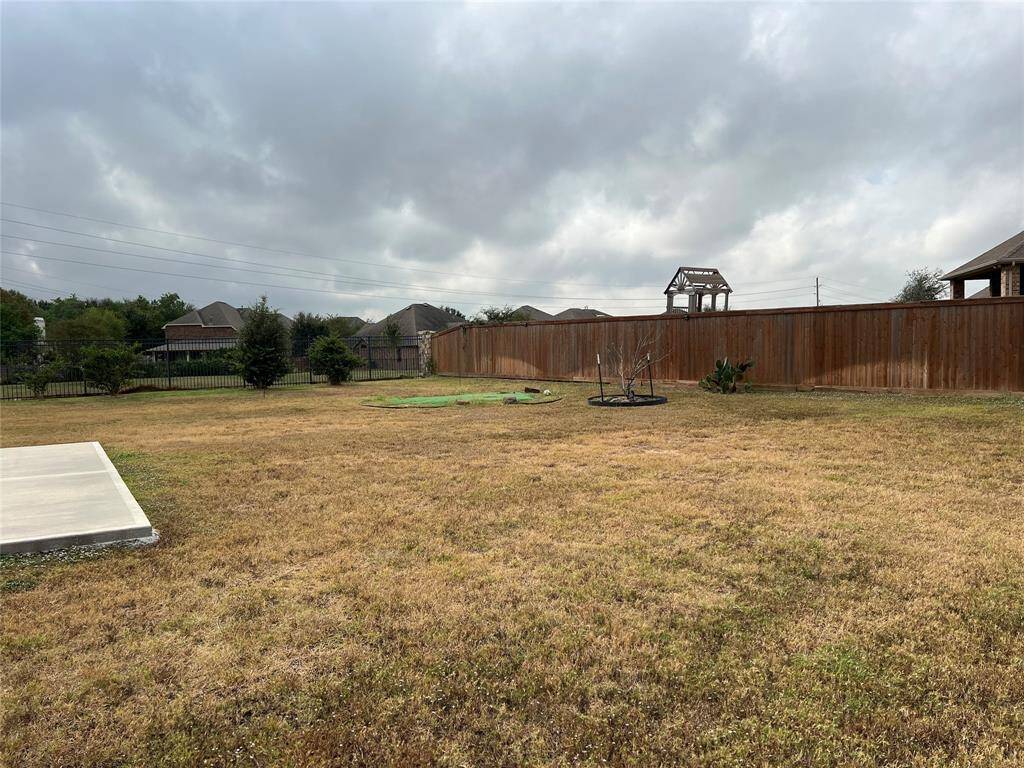View from back patio, looking at large slab that can be used for a firepit, extended patio area or future pool house.