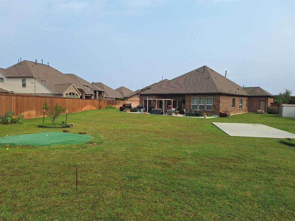 View from back fence line showing Putting Green, seperate slab and back view of huge backyard.