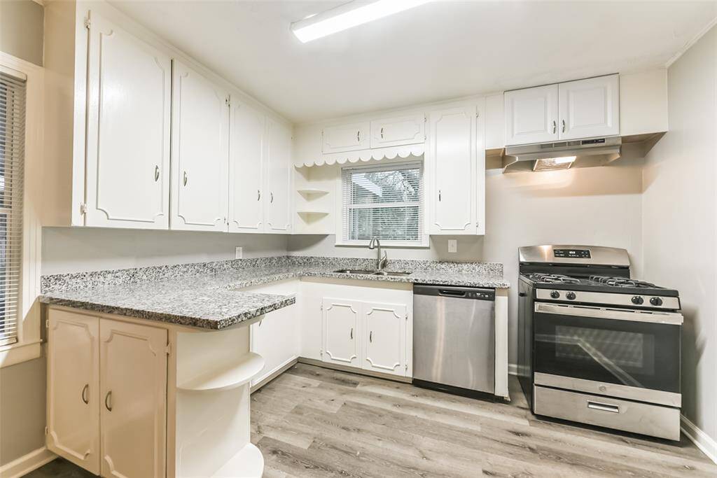 Kitchen has granite counters, stove and dishwasher