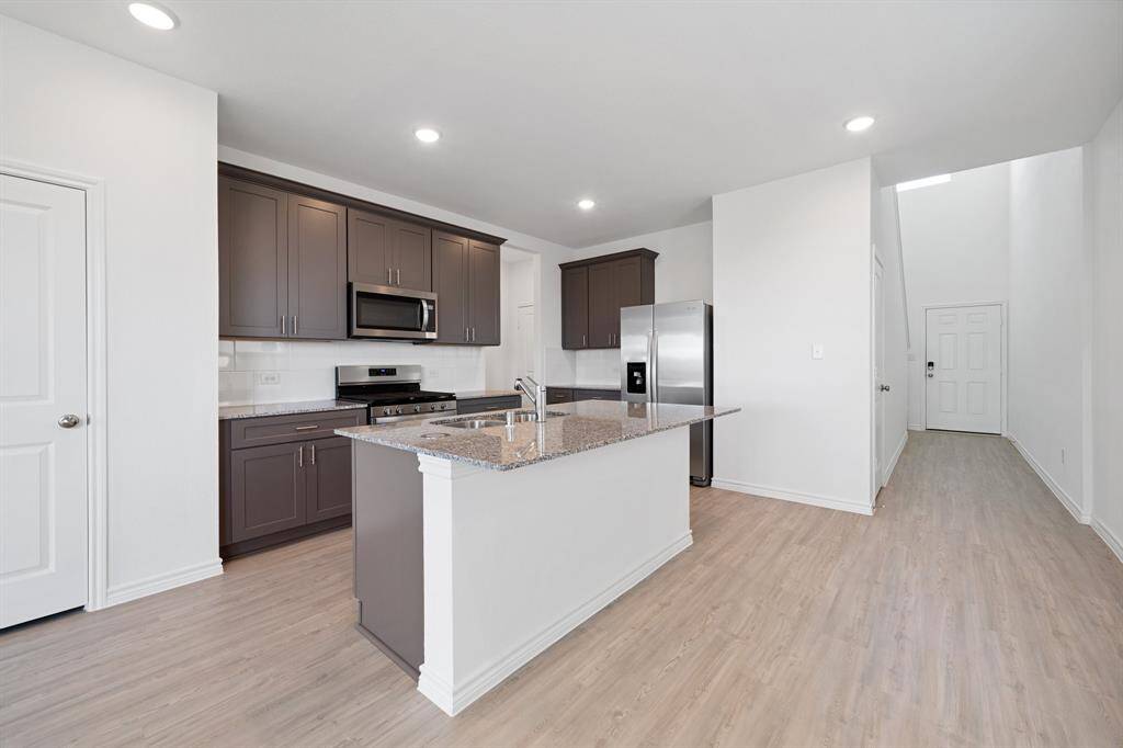gorgeous island kitchen with 42” inch serene grey cabinets, granite countertops, all the storage, and whirlpool stainless steel appliances