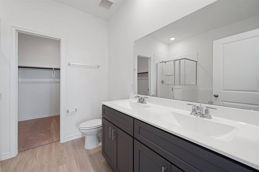 primary ensuite bathroom with double sinks, garden tub, and walk0in shower