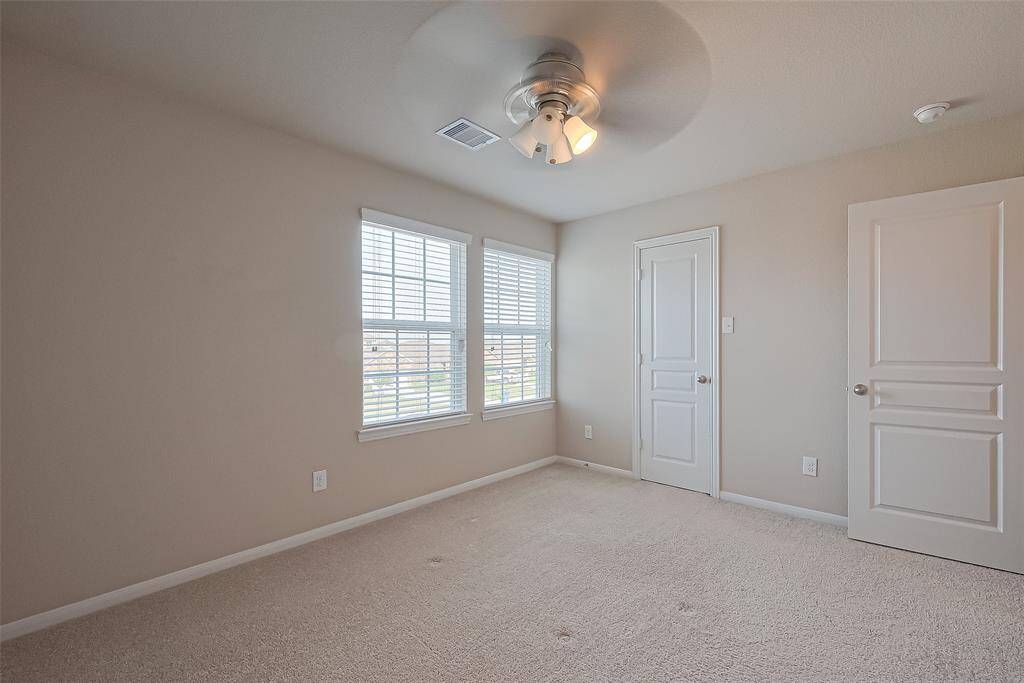 Secondary bedroom upstairs with ceiling fan.