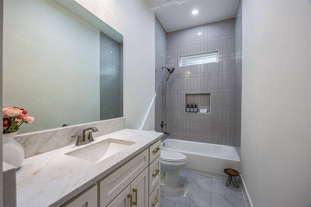 Luxurious tile extends all the way to the ceiling, creating a seamless, polished look and adding a touch of elegance to the space.