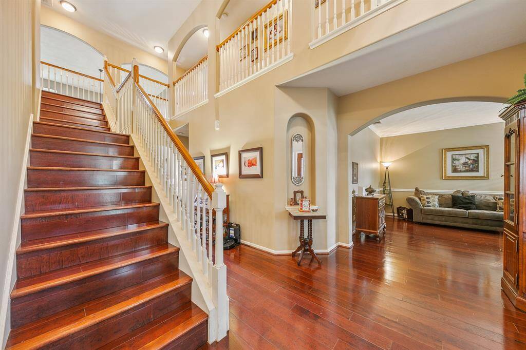 Gorgeous wood planked staircase (one of two) merges with a staircase off the kitchen at the landing halfway up.