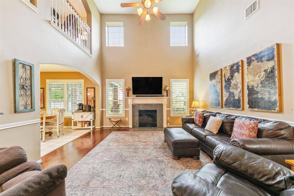 Stunning family room with soaring ceilings, a warm fireplace and windows for lake view enjoyment!
