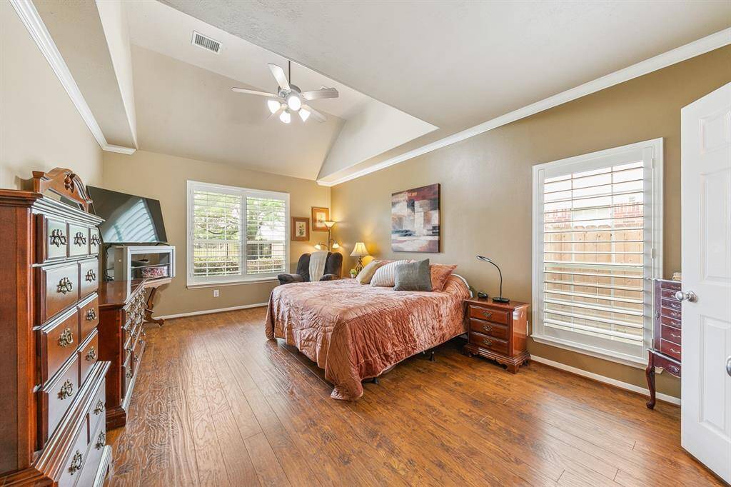 Primary owner's retreat is accessed through a an alcove and features the continuous wood floors, lake views and an sloped traded ceiling!