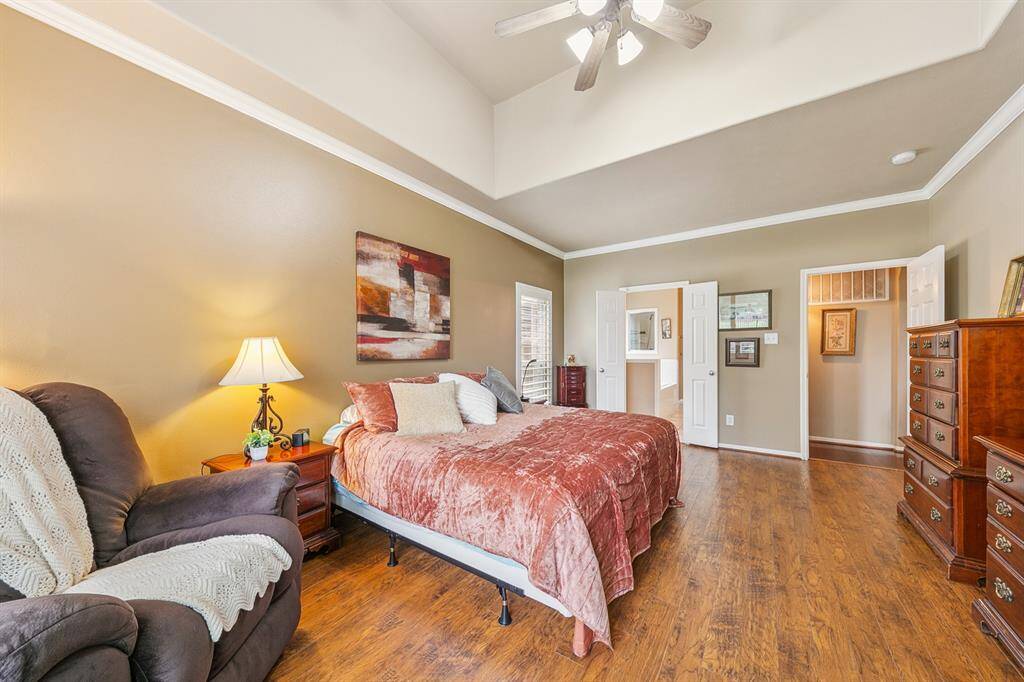 Spacious primary bedroom with crown moldings, ceiling fan and ensuite bath.