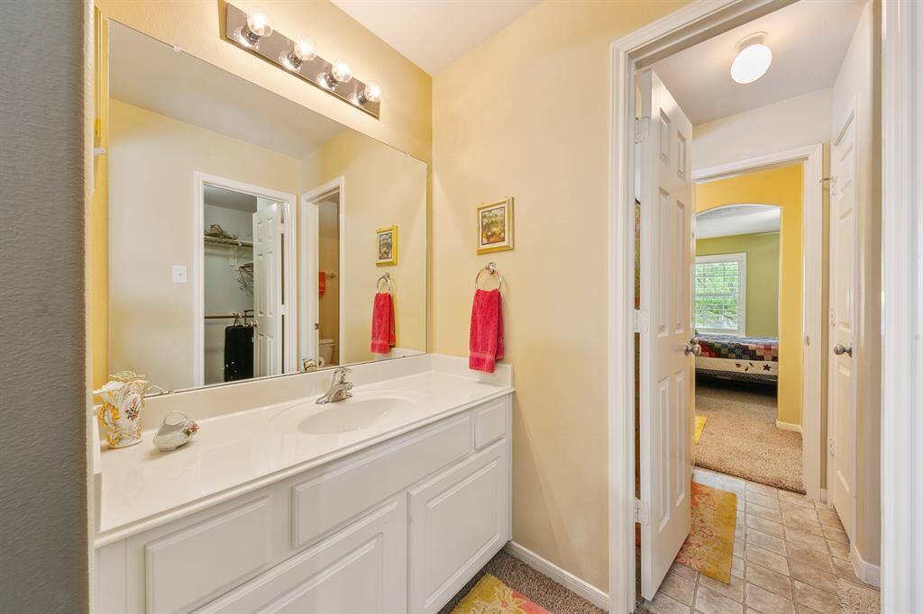 Hollywood bath located between both guest rooms shares a toilet, features a sink on each side and a linen closet.