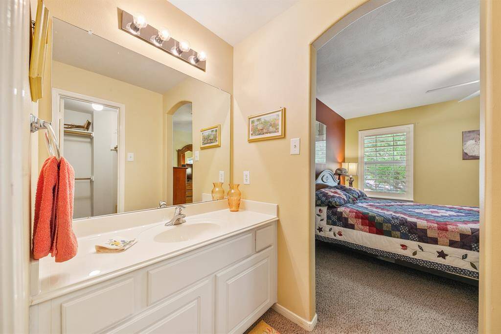 Spacious Hollywood bath with spacious opening to the second guest room, features personal sink and arched opening.