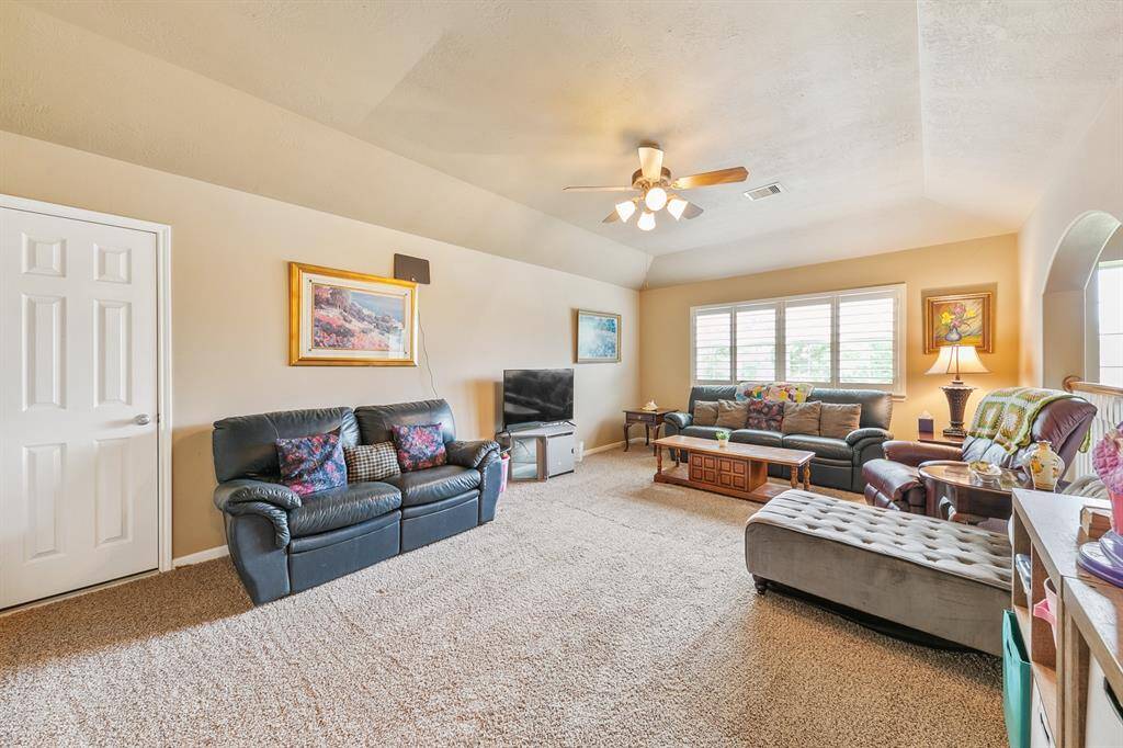 Family room with a coffered ceiling, fan, custom shutters, access to a full bath and a walk-in attic.