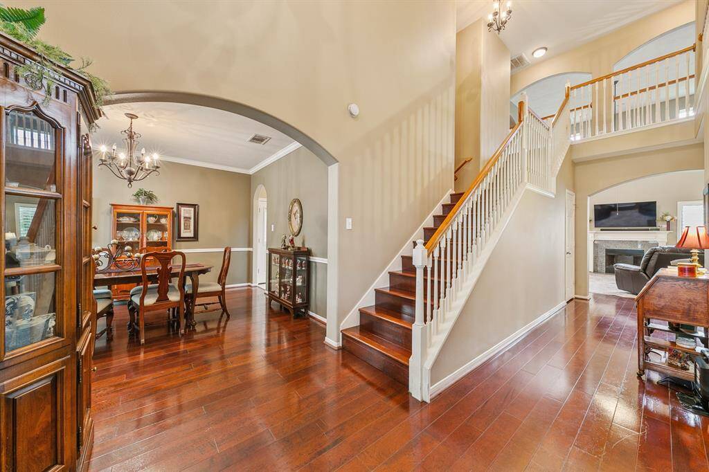 Inviting entry anchored by handsome hardwood floors!  To the left is the dining room defined by a large timeless arch.  Not depicted in this photo - to the right is the sitting room.