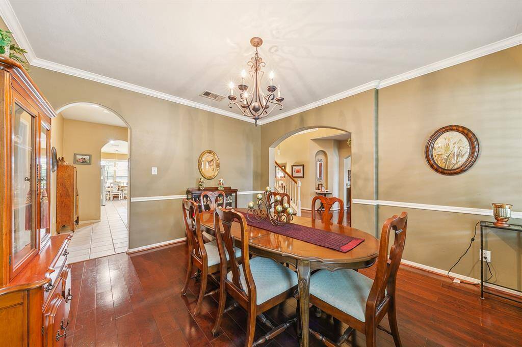 Spacious dining room accesses the entry area and the kitchen through arched openings.