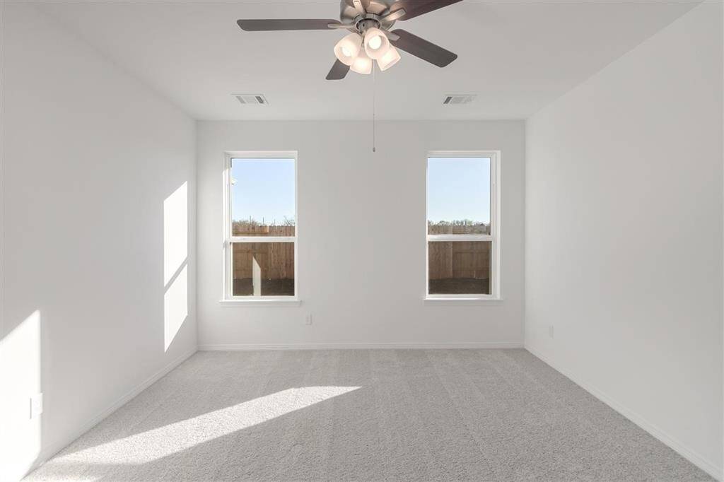 Natural sunshine spills through the windows of this generously-sized main bedroom!