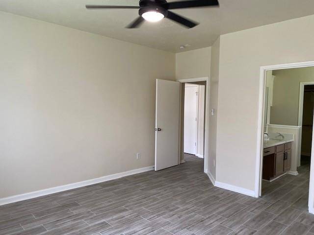 Elegant primary bedroom featuring modern flooring and direct ensuite access.