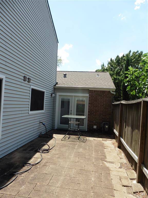 This photo shows a view from the back yard. Feathers a cozy patio with paved flooring, and privacy fencing. Perfect for Barbecuing. and outdoor relaxation or entertaining.