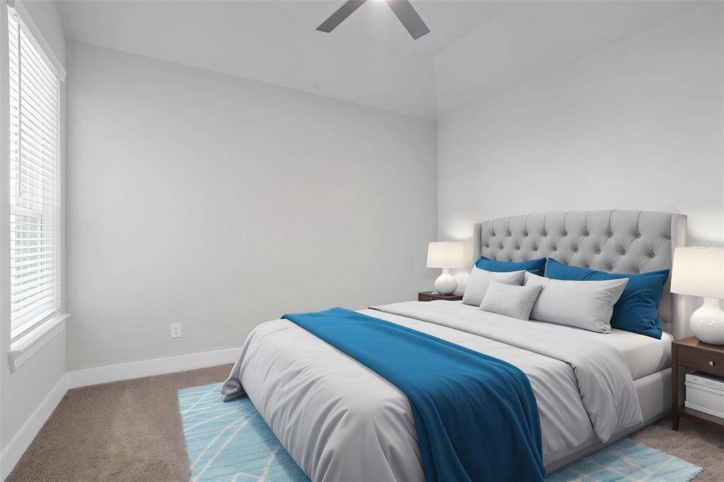 Secondary bedroom features plush carpet, custom paint, ceiling fan, closet space, and a large window with blinds.