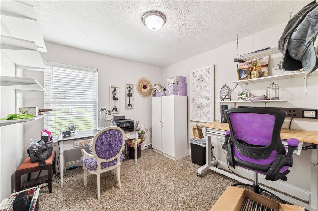 One of the secondary bedrooms is currently used as crafting room with plenty of space, natural lighting and plush floor covering.