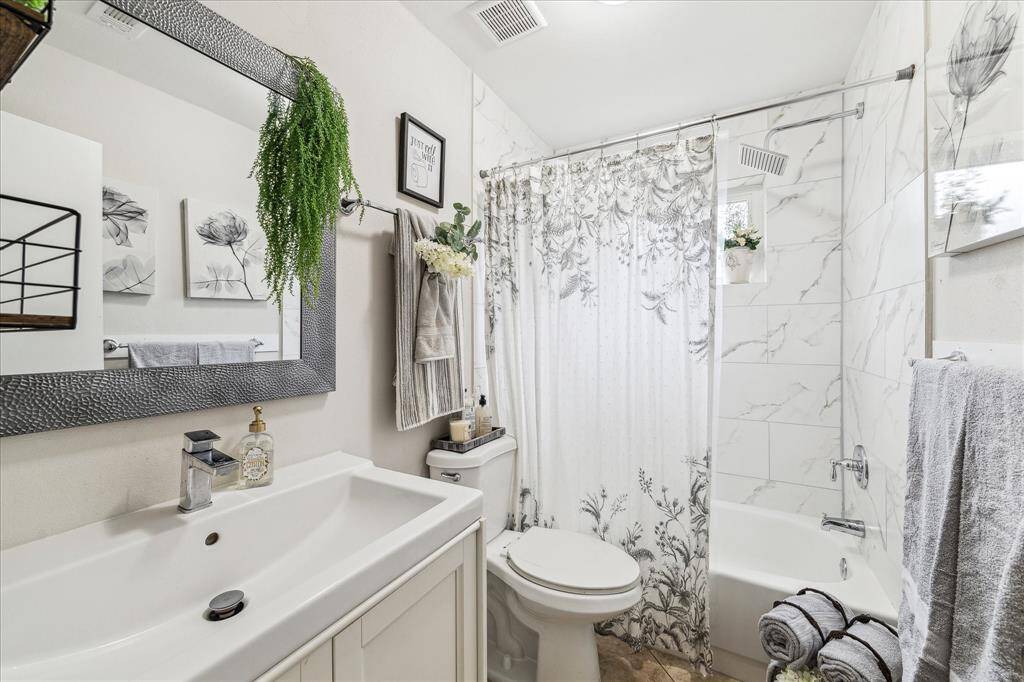 Secondary bathroom with new vanity, natural lighting, new faucets and relaxing tub.