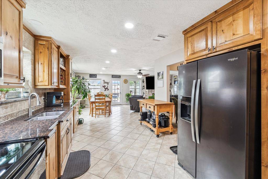 Recessed lighting brightens this open kitchen with custom wine rack and crown molding.
