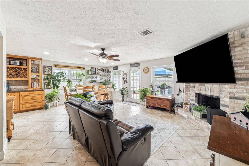 Light, bright, and open living space is inviting.  The floor to ceiling brick fireplace offers a cozy and comfortable feel.