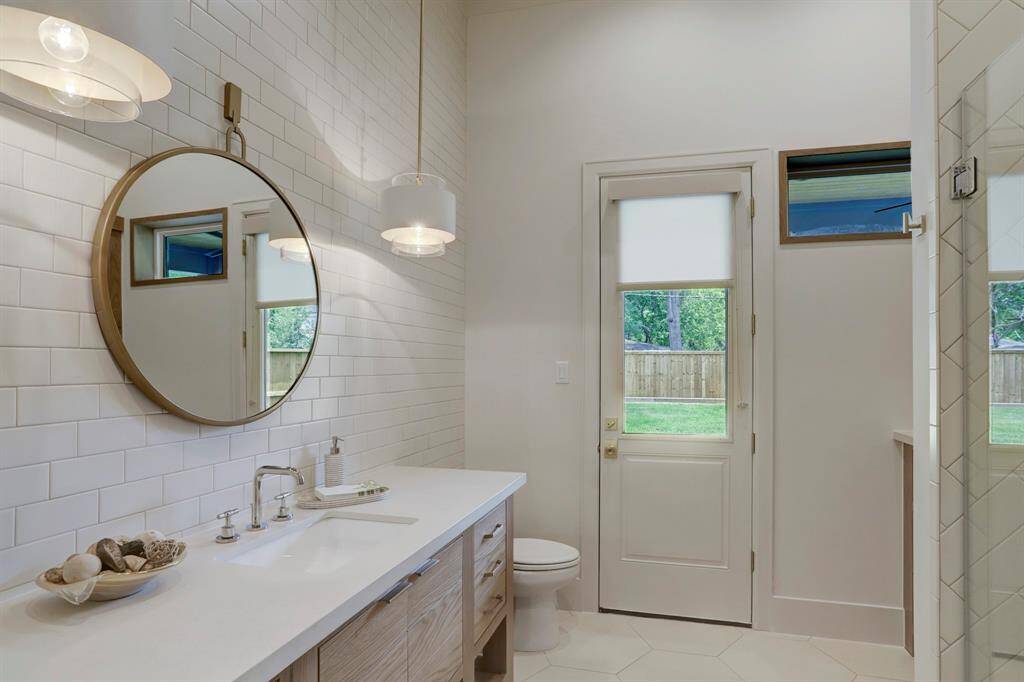 Full bathroom located off the sunroom and next to the 5th bedroom on the first level.  Also offers access to the back patio and backyard.
