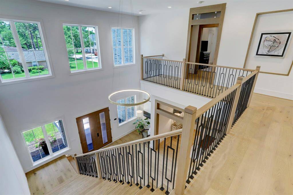 Upstairs landing that showcases the 2 story ceilings and abundance of windows offers ample natural lighting throughout.