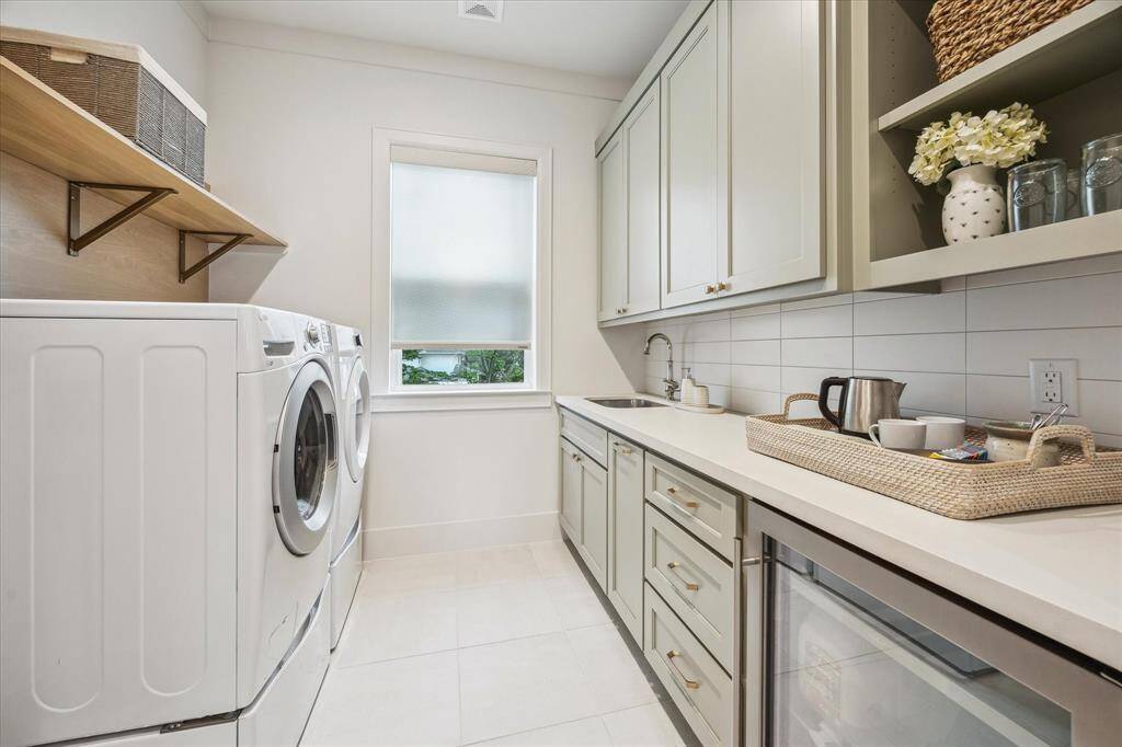 Utility room and coffee bar outfitted with secondary beverage cooler is located on the second level adjacent to the primary suite.