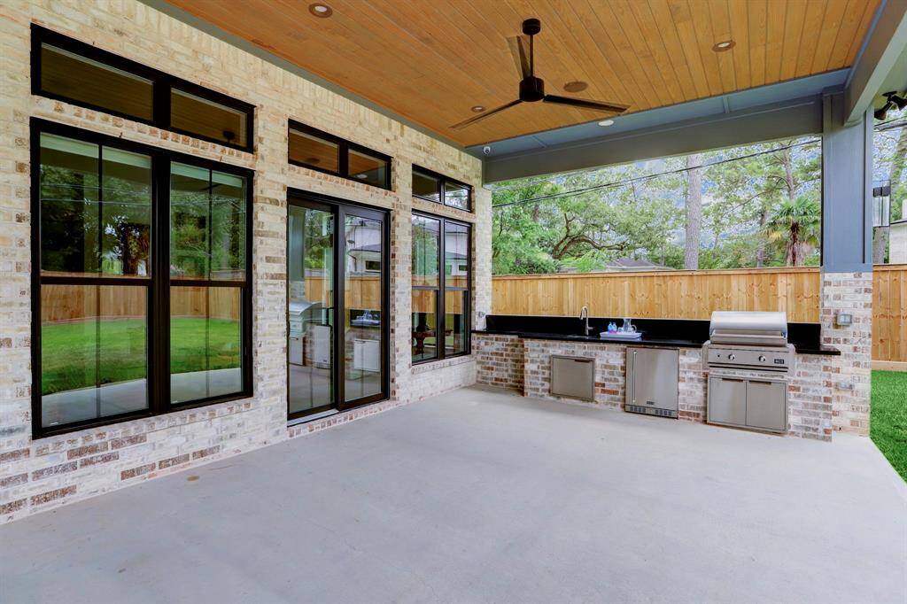Upclose view of the wood inlay ceiling, and outdoor kitchen space.  Great for entertaining.Outdoor kitchen with built-in grill, sink and refrigerator.