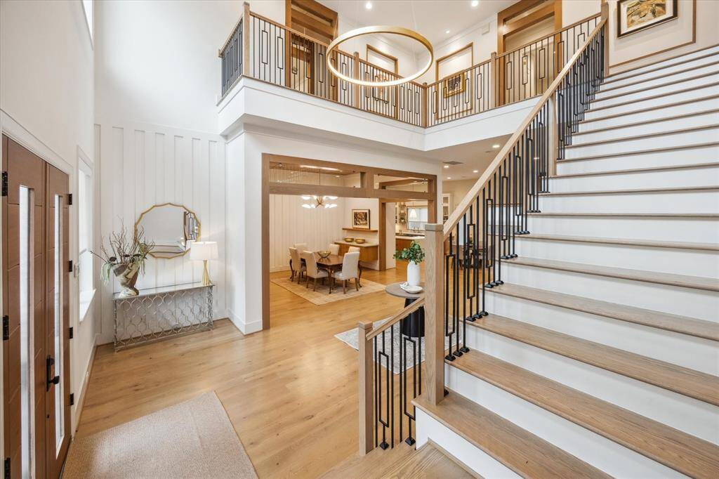 The iron and wood stair railing, Circa and Hudson Valley lighting, and a porcelain slab surround highlighting the fireplace are just a few of the designer elements showcased in this grand entry.