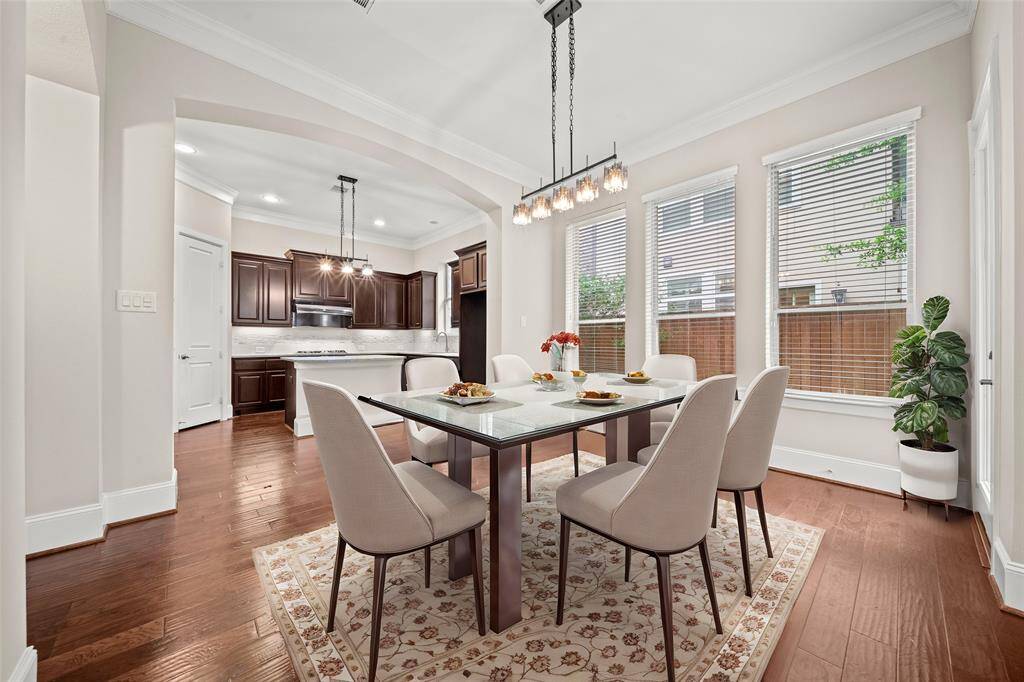 Elegant dining space with crown molding and natural light.(Virtual Staged)