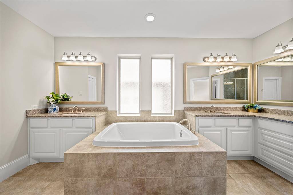 Luxurious bath area featuring a soaking tub and serene finishes.