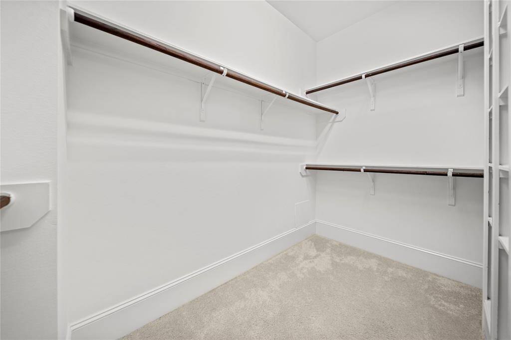 Spacious walk-in closet with built-in shelves and hanging space.