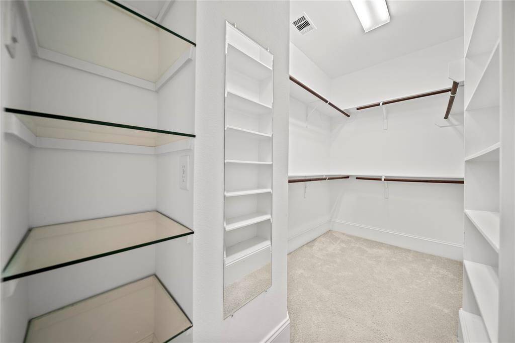 Spacious walk-in closet with built-in shelves and hanging space.