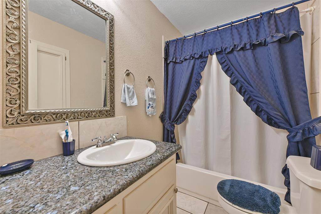 This full bathroom features a shower/tub combo, designated vanity space and ample storage.