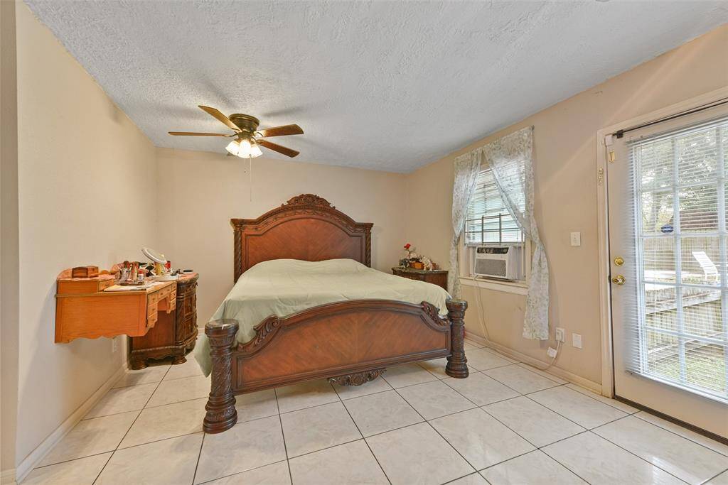 This large bedroom features backyard access and window-unit A/C for personalized comfort.