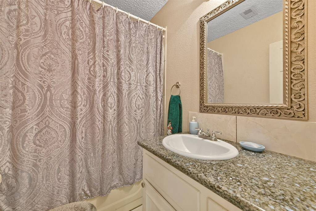 The ensuite full bathroom features a well-appointed vanity space and shower/tub combo.