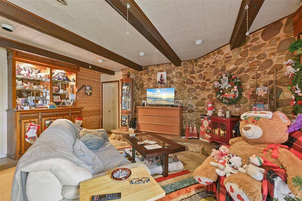 This living space offers charming cobblestone-style wall features and beamed ceilings.