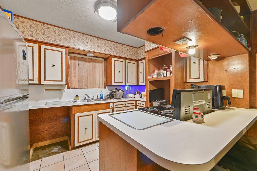 This kitchen offers ample cabinet storage, designated cutting-board countertop and electric appliances.