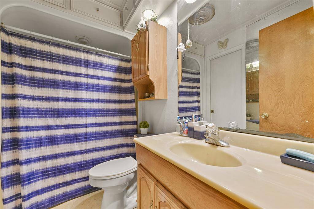 This ensuite bathroom features a shower/tub combo and a spacious vanity.