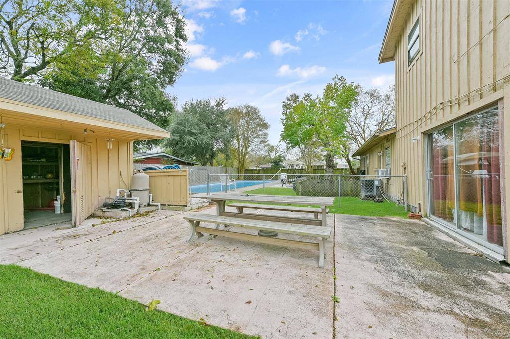 From the sliding glass doors of the main house, enjoy seamless entry to the outdoor living space with fenced-in pool area for safety.