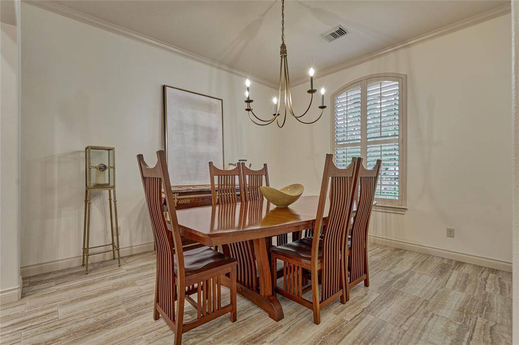 The dining room is exquisite with it's new wood-look tile floors, plantation shutter and statement chandelier.