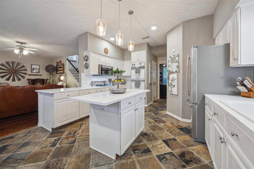 View of kitchen and family room from the back door includes double electric ovens.