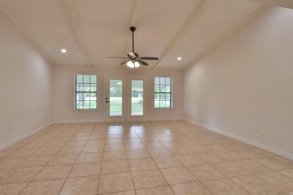 LIVING ROOM WITH HIGH CEILINGS AND FRENCH DOORS TO BACK PATIO AND YARD