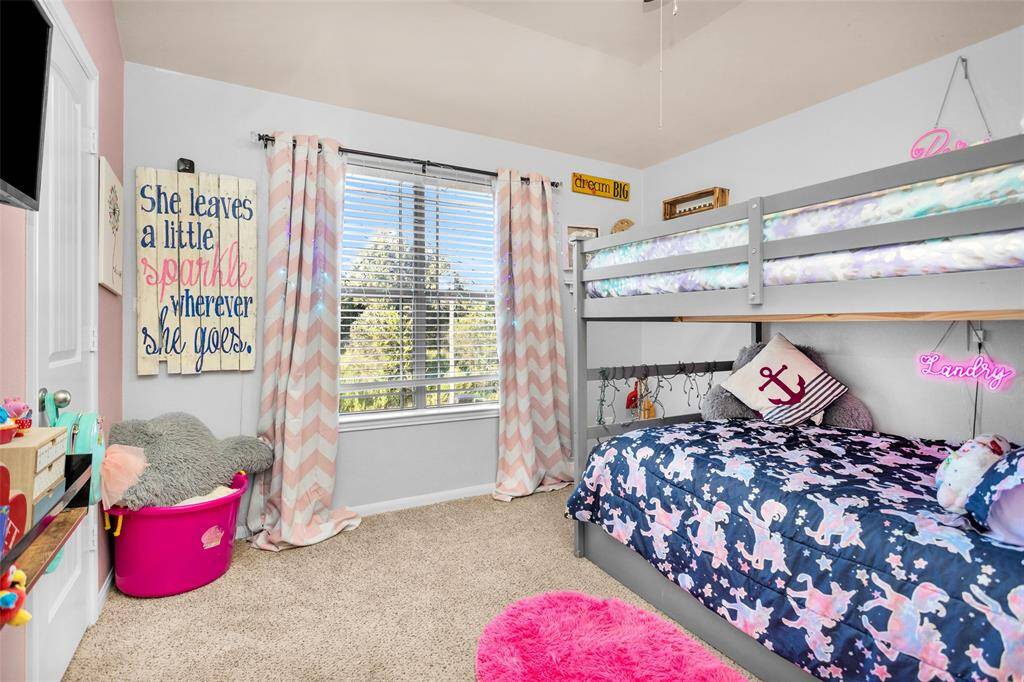 secondary bedroom upstairs with a view of the front yard.