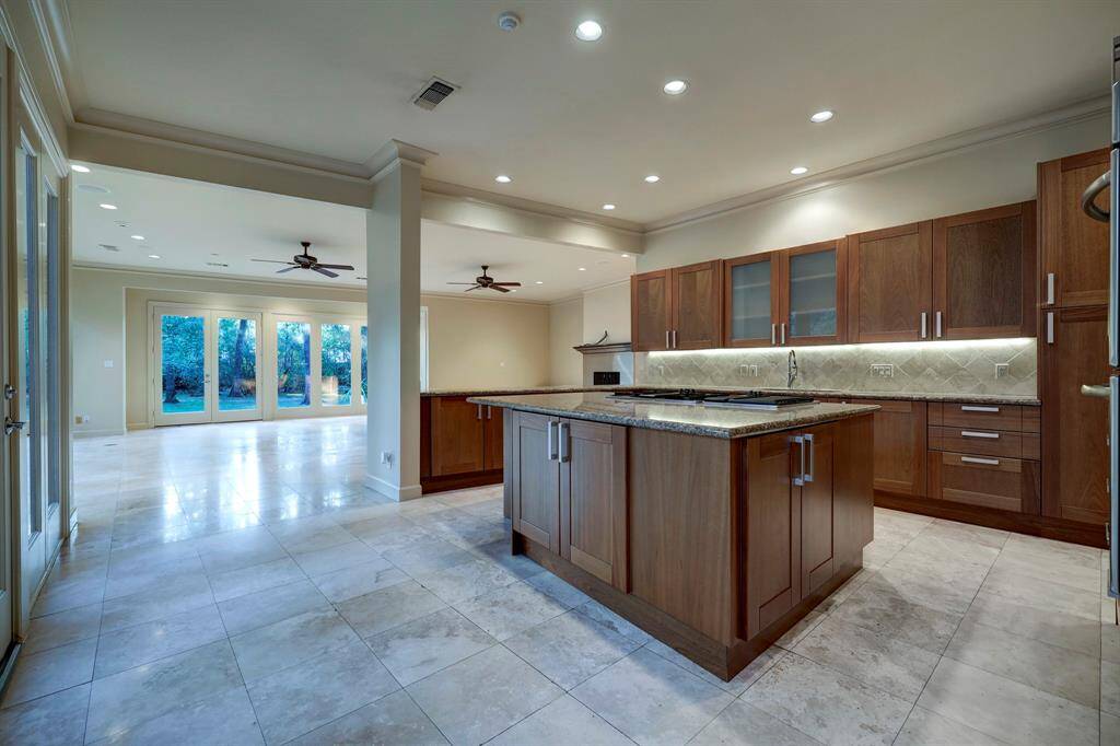 Updated kitchen enjoys a stainless steel appliance package, large island, custom cabinetry, and serving counter to the family room with fantastic views of the backyard.