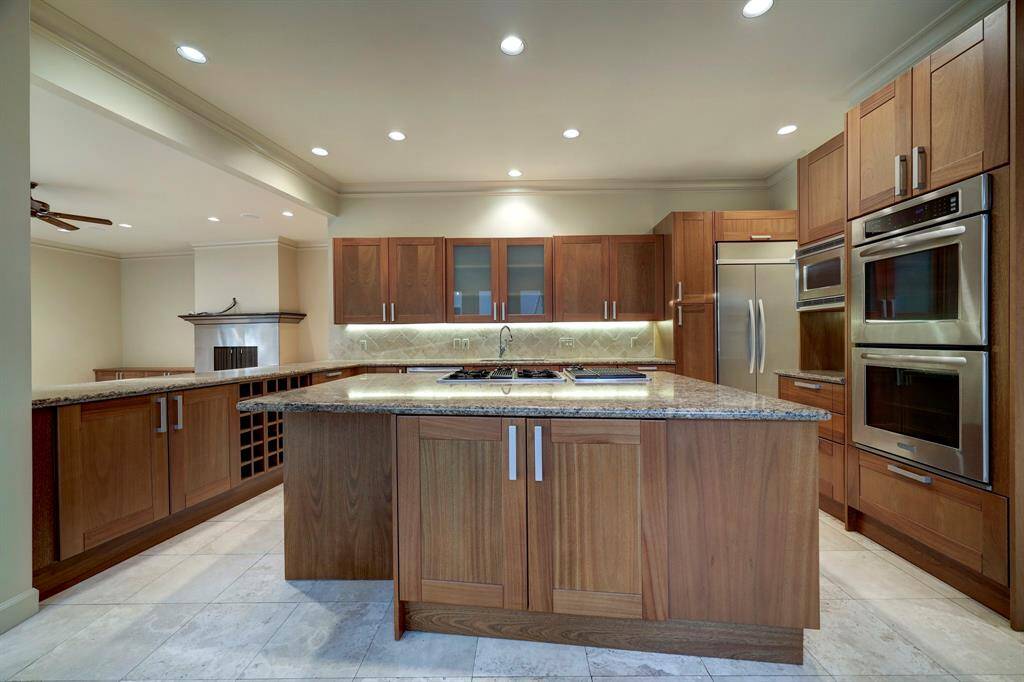 The island and countertops with granite with travertine tile backsplash. Great custom cabinetry with soft close drawers.