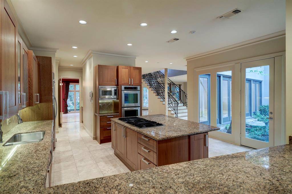 Another view of the kitchen with abundant counter space. There is a full-lite door to the backyard area.